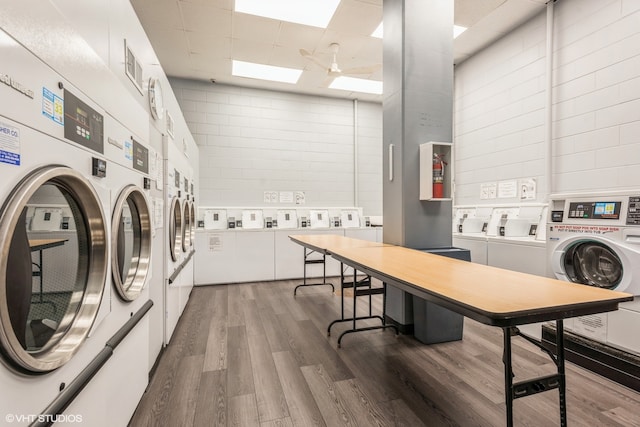 washroom featuring stacked washer and dryer, washing machine and dryer, and wood-type flooring