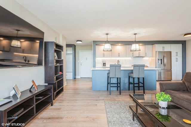 living room with light hardwood / wood-style floors and sink