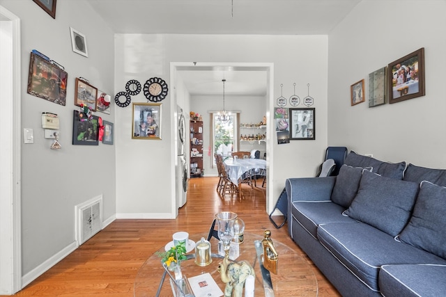 living room featuring hardwood / wood-style flooring and an inviting chandelier