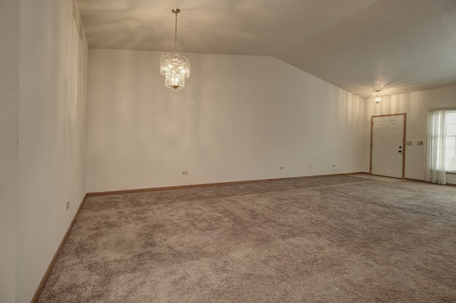 spare room featuring vaulted ceiling, an inviting chandelier, and carpet flooring