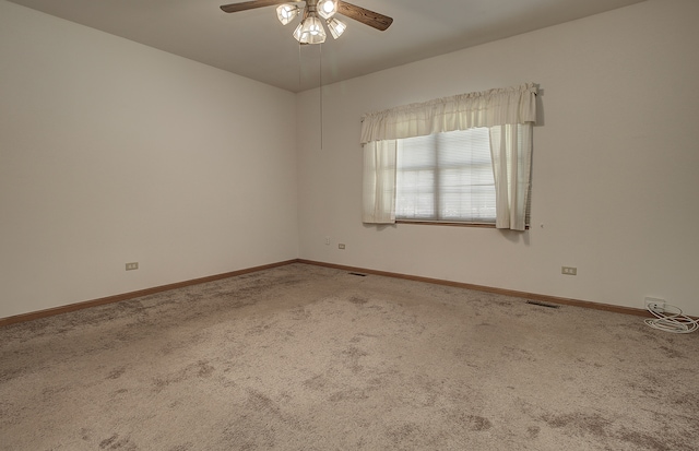 carpeted spare room with ceiling fan