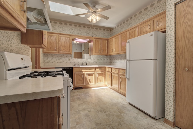 kitchen featuring backsplash, sink, a skylight, white appliances, and ceiling fan