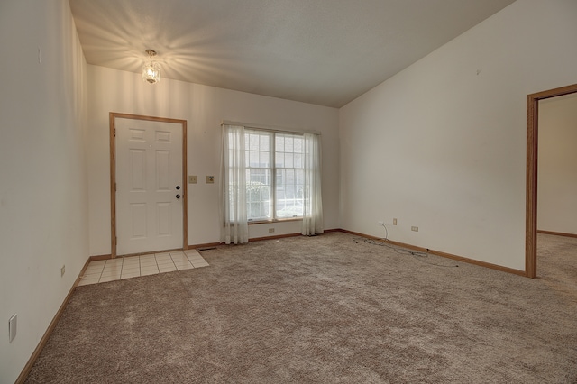 carpeted entrance foyer featuring vaulted ceiling