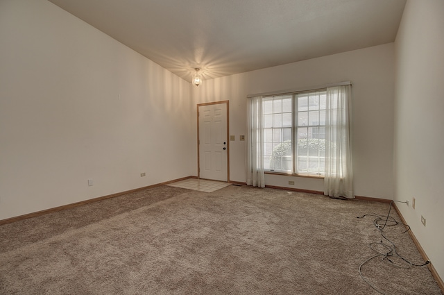 unfurnished room featuring light carpet