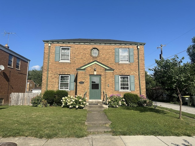 view of front of property with fence, a front lawn, and brick siding