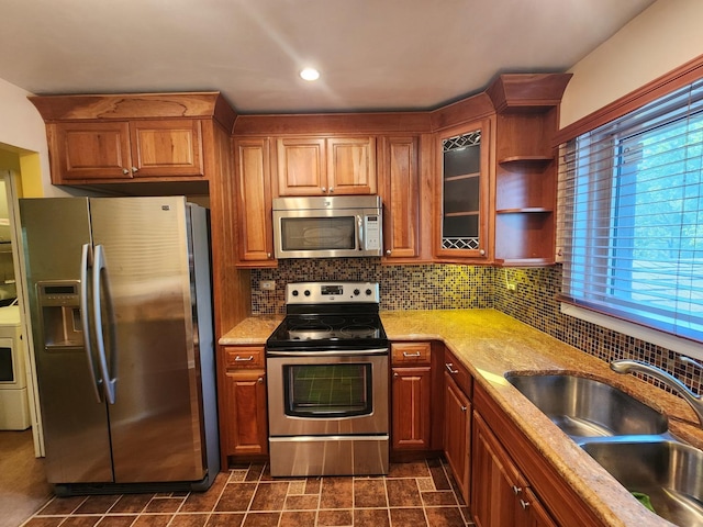 kitchen featuring plenty of natural light, sink, stainless steel appliances, and decorative backsplash