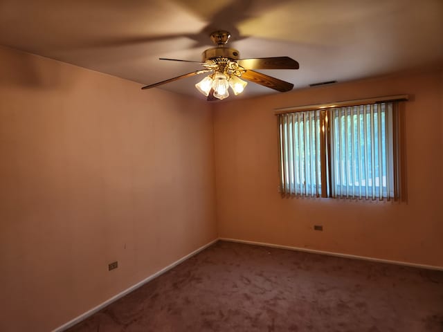 carpeted spare room featuring ceiling fan