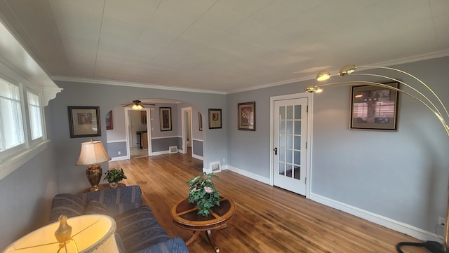 living room featuring ceiling fan, crown molding, and wood-type flooring