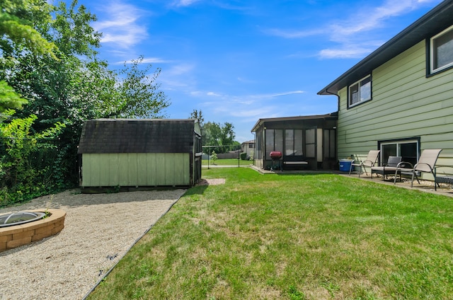 view of yard featuring a sunroom, a patio, a fire pit, and a storage unit