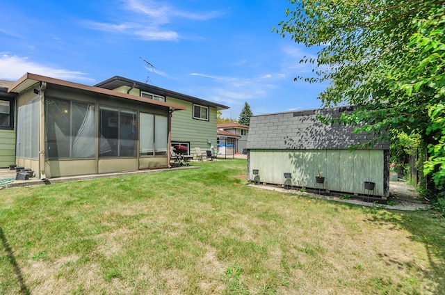 rear view of house with a sunroom and a yard