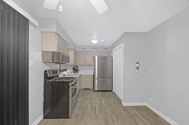 kitchen with light brown cabinets, stainless steel appliances, light hardwood / wood-style flooring, and sink