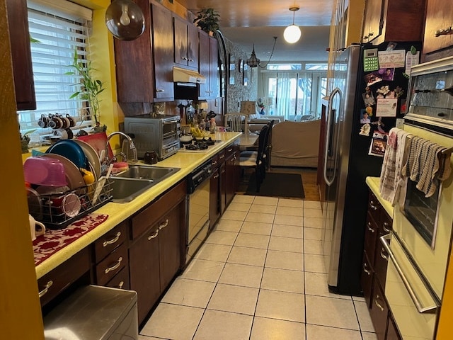 kitchen with sink, refrigerator, black dishwasher, and light tile patterned floors