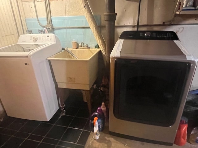 clothes washing area featuring sink, separate washer and dryer, and tile patterned floors