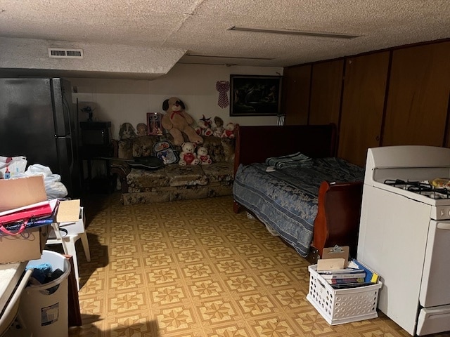 bedroom featuring a textured ceiling and black fridge