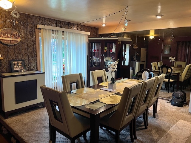 dining area with carpet and rail lighting