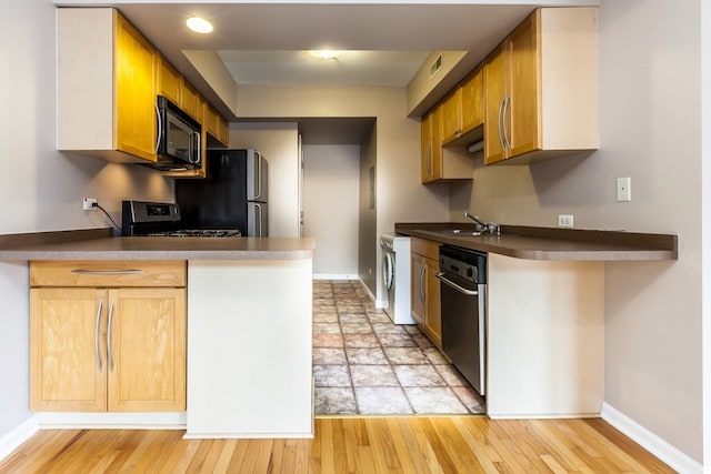 kitchen featuring light wood-type flooring, kitchen peninsula, range, and dishwasher