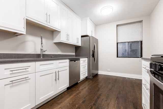 kitchen featuring white cabinetry, sink, stainless steel appliances, and dark hardwood / wood-style flooring