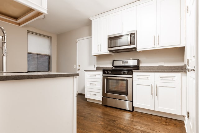 kitchen with dark hardwood / wood-style floors, stainless steel appliances, and white cabinets