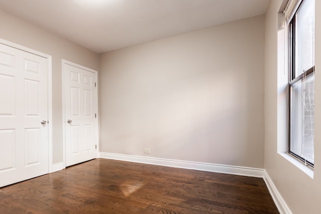 unfurnished bedroom with dark hardwood / wood-style floors