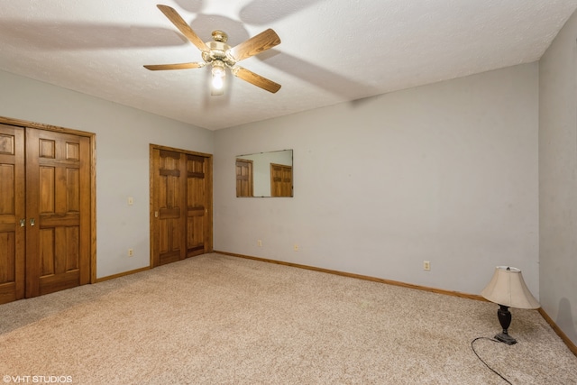 unfurnished bedroom featuring a textured ceiling, carpet floors, and ceiling fan