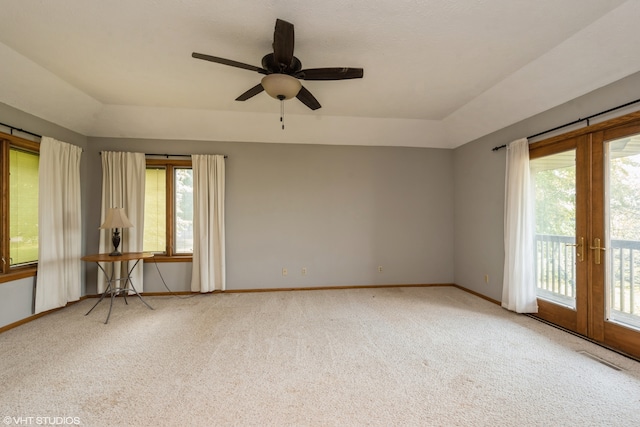 carpeted spare room featuring ceiling fan, french doors, and a healthy amount of sunlight