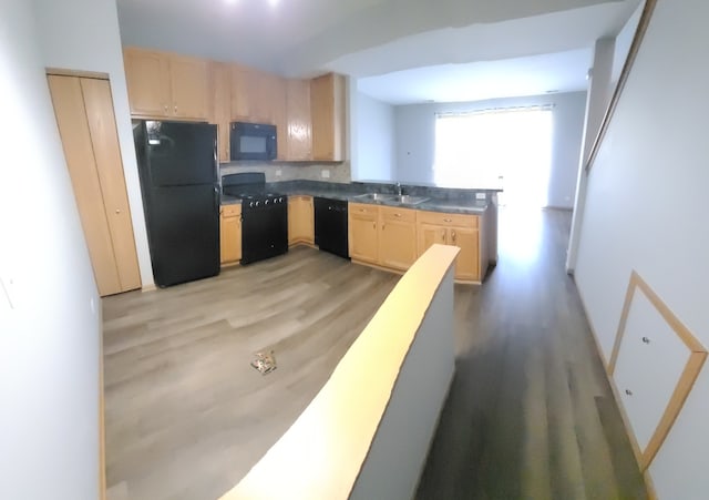 kitchen with sink, light hardwood / wood-style flooring, light brown cabinets, and black appliances