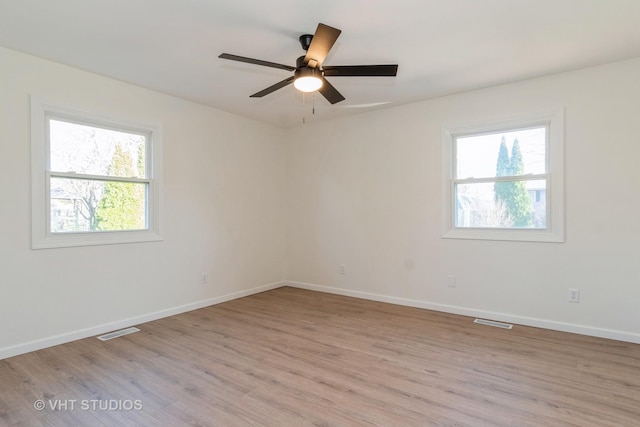 spare room featuring ceiling fan, a healthy amount of sunlight, and light hardwood / wood-style floors