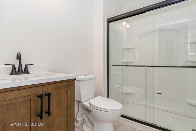 bathroom featuring an enclosed shower, vanity, toilet, and tile patterned flooring