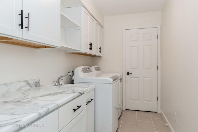 laundry room featuring cabinets, sink, washer and dryer, and light tile patterned flooring