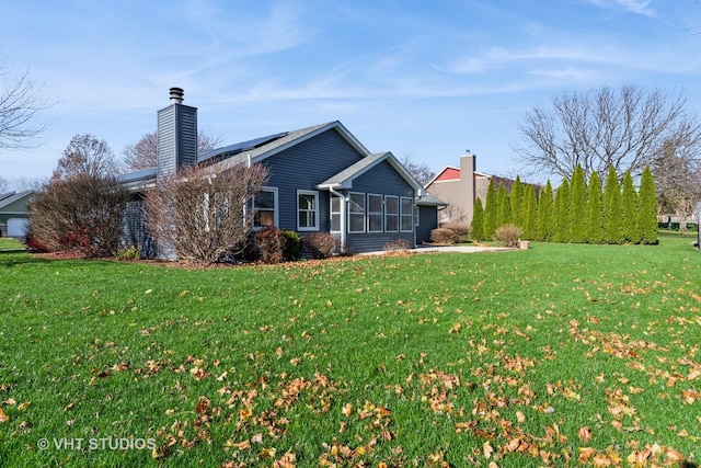 back of house featuring a lawn and a sunroom