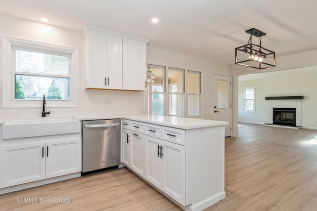 kitchen featuring white cabinetry, dishwasher, light hardwood / wood-style floors, and sink