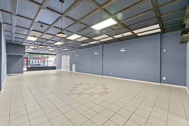 unfurnished room with basketball hoop, light tile patterned flooring, and coffered ceiling