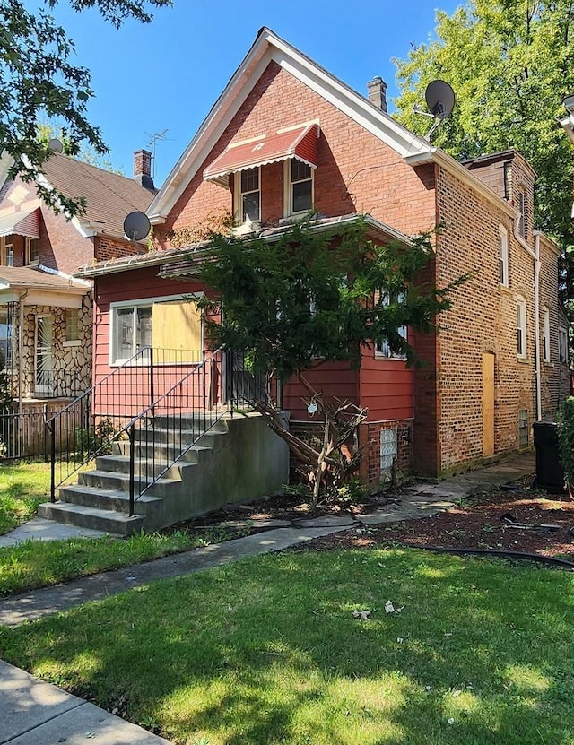 bungalow-style house featuring brick siding, a front lawn, and a chimney