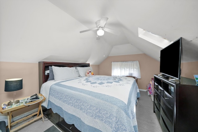 carpeted bedroom featuring lofted ceiling with skylight and ceiling fan