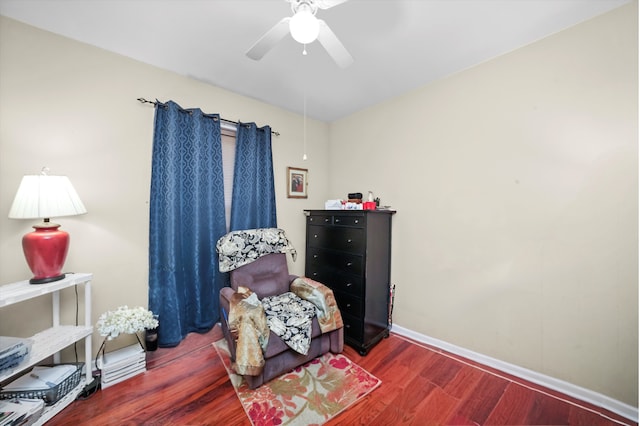 living area featuring ceiling fan and dark hardwood / wood-style flooring