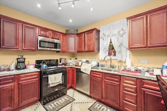 kitchen featuring sink, appliances with stainless steel finishes, and light stone counters