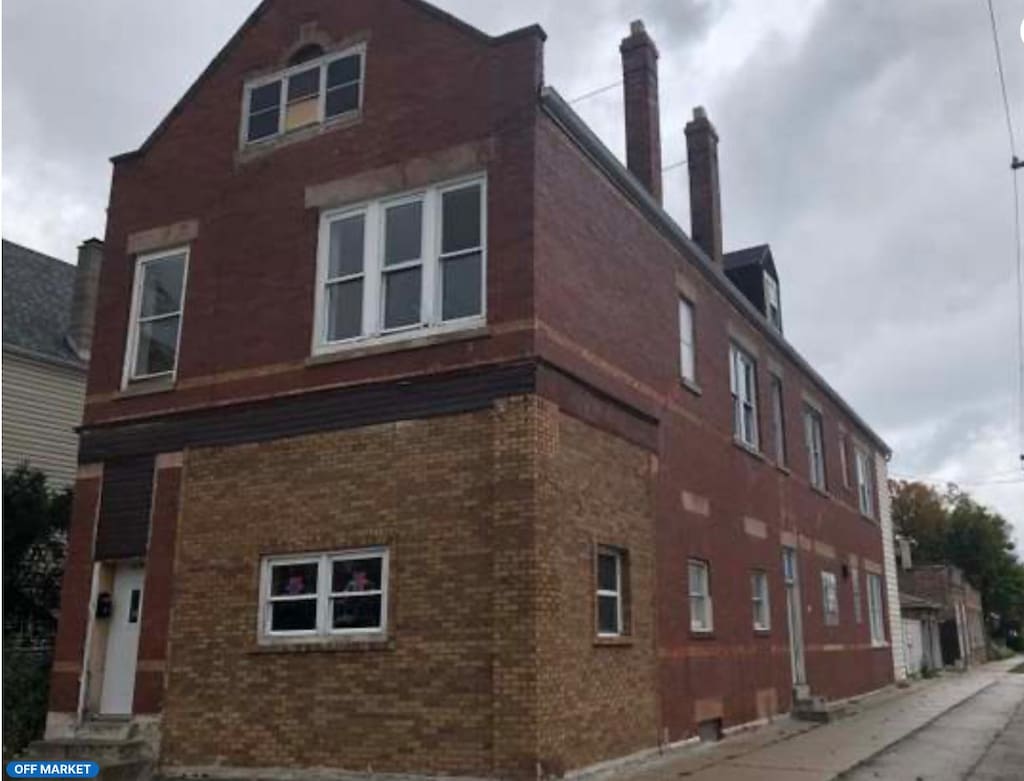 view of property exterior featuring a chimney and brick siding