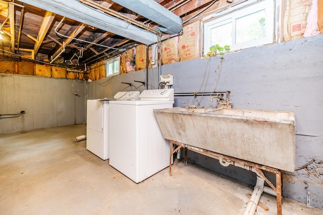 washroom featuring laundry area, washer and clothes dryer, and a sink