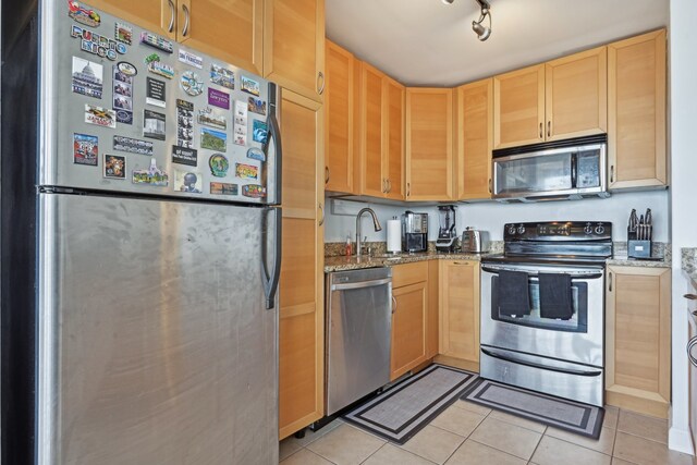 kitchen with sink, rail lighting, appliances with stainless steel finishes, and light tile patterned floors