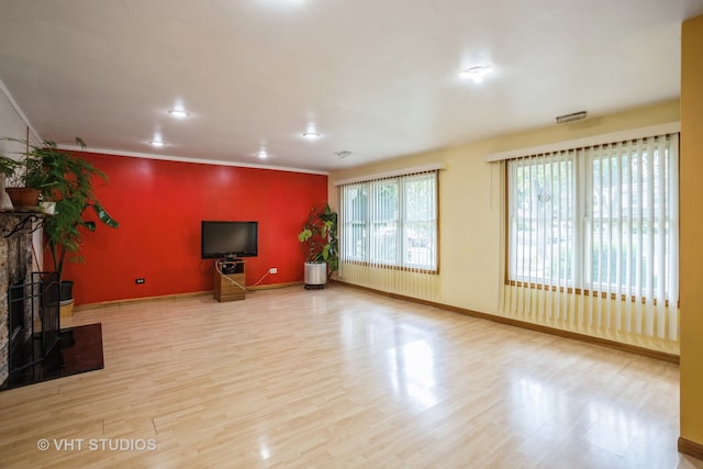 unfurnished living room with light wood-type flooring and a wood stove