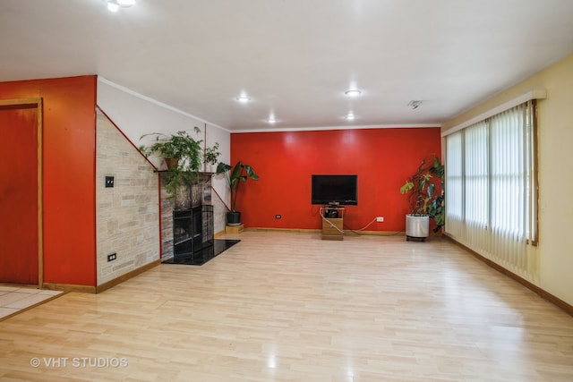 living room featuring a fireplace, light hardwood / wood-style flooring, and ornamental molding