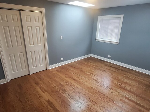 unfurnished bedroom featuring hardwood / wood-style flooring and a closet