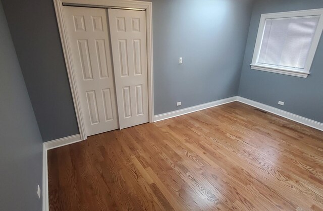 unfurnished bedroom with a closet and light hardwood / wood-style floors