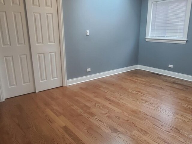 unfurnished bedroom featuring hardwood / wood-style floors and a closet