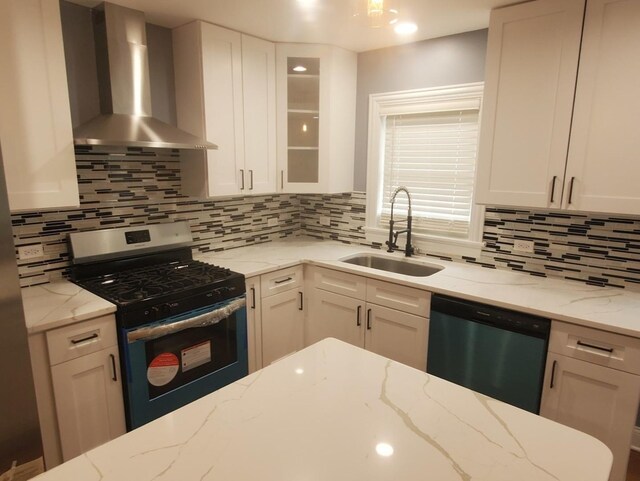 kitchen featuring wall chimney exhaust hood, stainless steel appliances, sink, and decorative backsplash