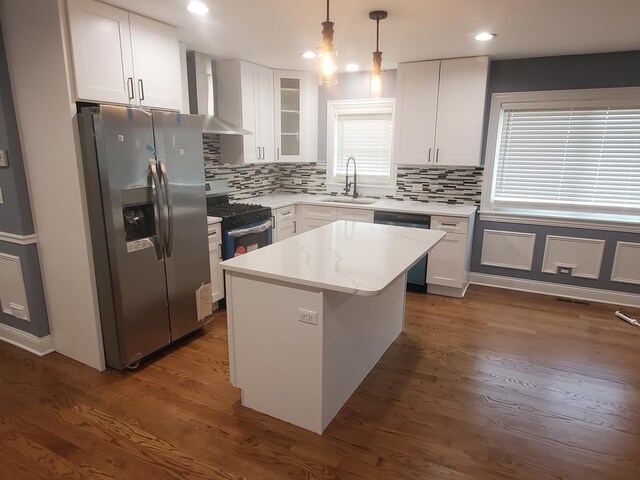 kitchen with sink, wall chimney range hood, stainless steel fridge, dark wood-type flooring, and gas range oven