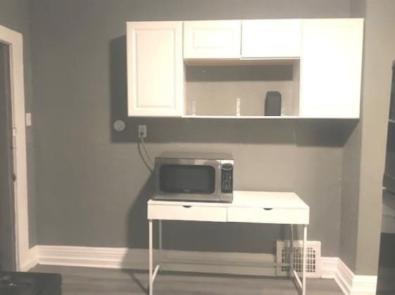 interior space featuring dark hardwood / wood-style floors and white cabinets