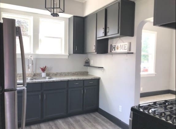 kitchen featuring sink, decorative light fixtures, light hardwood / wood-style flooring, and stainless steel fridge