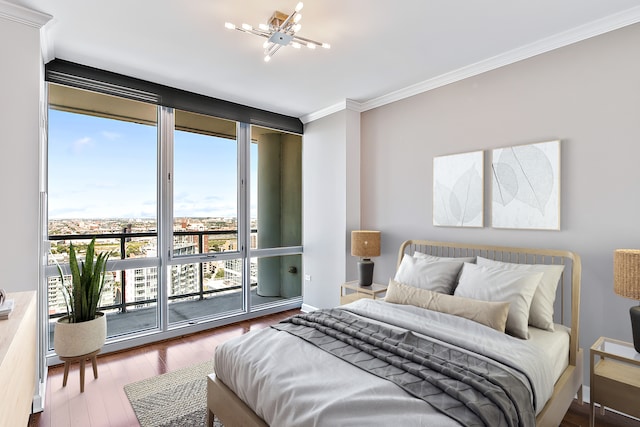 bedroom featuring access to outside, an inviting chandelier, hardwood / wood-style floors, and ornamental molding