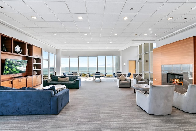 living room with carpet, plenty of natural light, a premium fireplace, and a water view